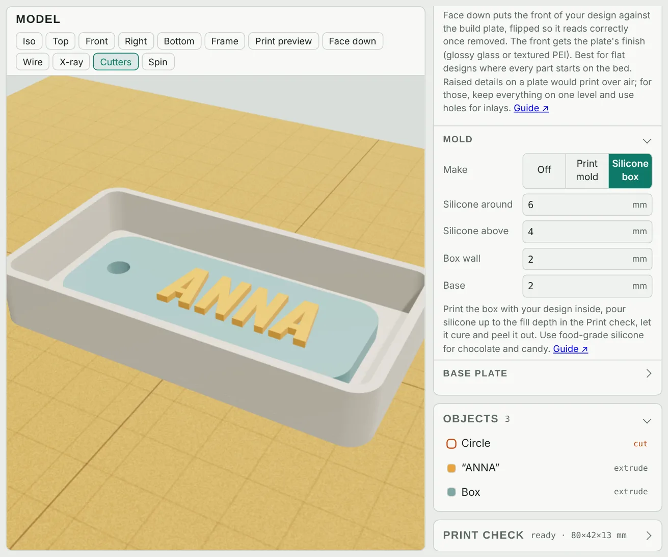 A silicone mold box with the design standing inside it